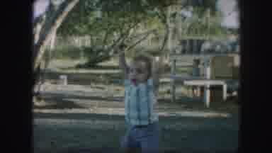 Kansas City Missouri (1959): A Baby Wearing A Shirt And Walking In A Yard In Front