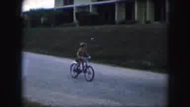 Kansas City Missouri (1959): Young Boy Riding His Bike In A Rush To Get Home Or
