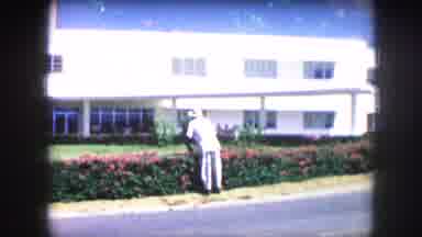 Kansas City Missouri (1959): White Building With Gardener Pruning Hedges Between