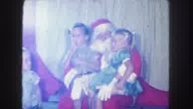 KANSAS CITY MISSOURI-1959: Two Young Children Sit On Santa's Lap And Tell Him