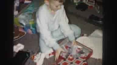Kansas City Missouri (1959): A Boy Quickly Uncovering A Gift Shows It And Sits