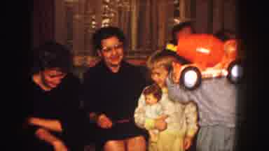 Kansas City Missouri (1959): A Family Sits On A Couch While Some Children Hold Up