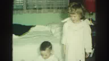 Kansas City Missouri (1959): Young Female Child In Nightgown Plays With Younger