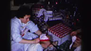 Lynbrook New York (1975): Woman Wearing Blue Shirt Putting White Christmas Hats On