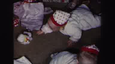 Lynbrook New York (1975): Babies Crawling On The Floor Wearing Hats With Parents