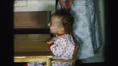 Lynbrook New York (1975): Young Toddler Laughs While At Table With Mother Or