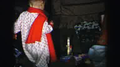 Lynbrook New York (1975): Baby In Red And White Pajamas Pulling Along Toy On A