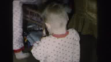 Lynbrook New York (1975): One Toddler Laughs With Glee While Playing With Toy And