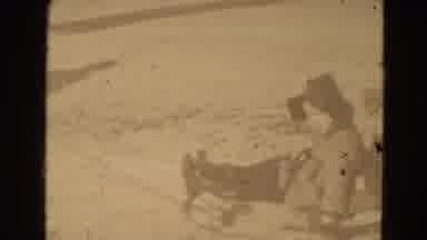 Lincoln Nebraska USA (1975): Two Children Playing By Riding A Sledge In Open Field