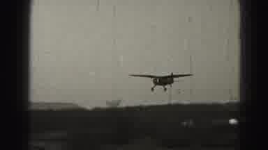 Harrisburg Pennsylvania USA (1975): An Older Model Airplane Flying Over A Grassy
