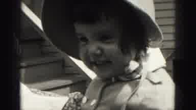 HARRISBURG PENNSYLVANIA USA-1975: Young Girl in White Hat Smoothing Hair