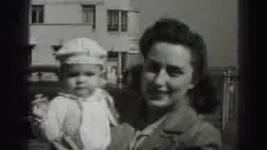 Harrisburg Pennsylvania USA (1975): Woman Holds Baby Wearing White Hat On A Bright