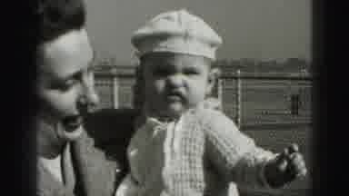 HARRISBURG PENNSYLVANIA USA-1975: Woman Holds Baby Wearing White Sweater And Hat
