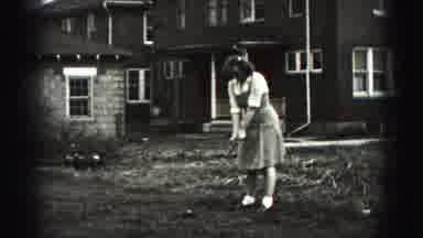 Harrisburg Pennsylvania USA (1975): Woman In Dress Hits Golf Ball In Front Of Old