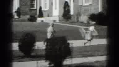 Middletown Pennsylvania (1975): Two Kids Run Down A Sidewalk Arriving At A New