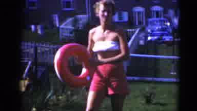 Middletown Pennsylvania (1975): Woman Pickups Pool Float As Another Holds A Baby