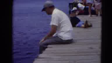 Middletown Pennsylvania (1975): Man In Baseball Cap And Polo Sitting On Crowded
