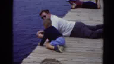 Middletown Pennsylvania (1975): Man And Boy Laying On Dock String Fishing In The