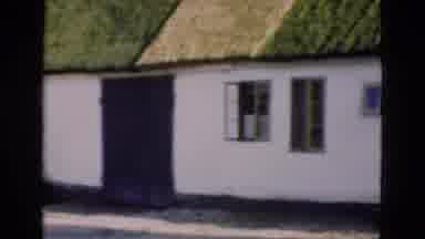 Denmark (1975): Outside Footage Of Long White Building Or Cottage With Green Grass