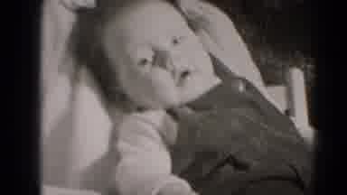Middletown Pennsylvania (1975): Infant Leaning Against Caregiver Sits Up