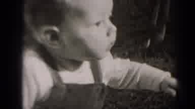 Middletown Pennsylvania (1975): A Baby Playing Wearing A Jumper Sitting On A