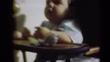 Middletown Pennsylvania (1975): Baby Wearing White Shirt Sits In Brown Highchair