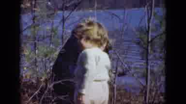 Middletown Pennsylvania (1975): Two Adults Kneeling By A Lake Watching A Toddler