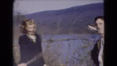 Middletown Pennsylvania (1975): A Man Stands Smoking While A Woman Poses To The