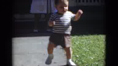 Middletown Pennsylvania (1975): Toddler Wearing Brown Striped Shirt Walks On