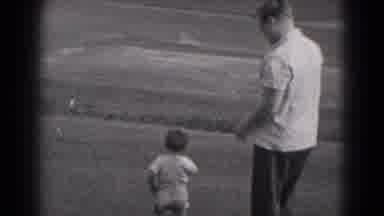 Middletown Pennsylvania (1975): Boy Runs On Grass To Point At Distant Moving