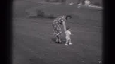 Middletown Pennsylvania (1975): A Mother Helps An Unsteady Toddler Walk Across The