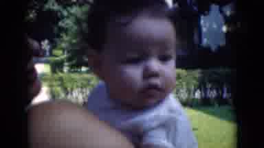 Middletown Pennsylvania (1975): Woman Holds Baby Wearing White Shirt On A Bright