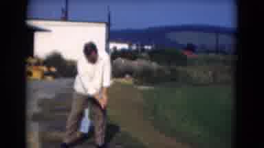 Middletown Pennsylvania (1975): Man Wearing White Shirt Swings Golf Club On Bright