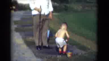Middletown Pennsylvania (1975): Father Watching Child In Shorts Play With Toy