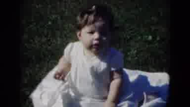 Middletown Pennsylvania (1975): A Baby Sits In The Grass Next To A Lake By Trees