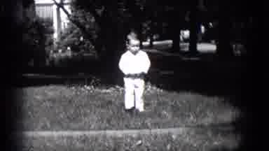 MIDDLETOWN PENNSYLVANIA-1975: Happy Little Boy Dressed In White Runs Towards The Camera