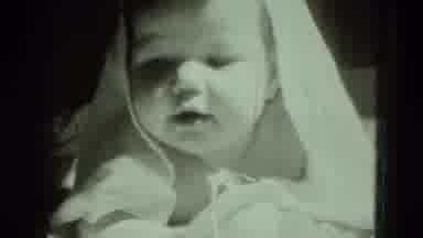 MIDDLETOWN PENNSYLVANIA-1975: Baby Under A White Blanket Looks Around As Someone