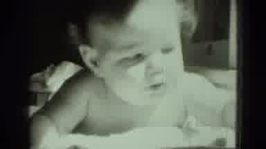 Middletown Pennsylvania (1975): A Baby Is Lying On The Bed And Playing With The