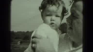 Middletown Pennsylvania (1975): Man Holds Baby Wearing White Shirt On A Bright