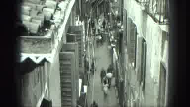 Venice Italy-1975: People Walking On Village Sidewalks On A Cloudy Day