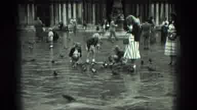 Venice Italy-1975: Small Children And Young Women Feed Several Pigeons At The