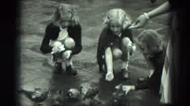 VENICE ITALY-1975: Three Children Feeding Pigeons With An Adult