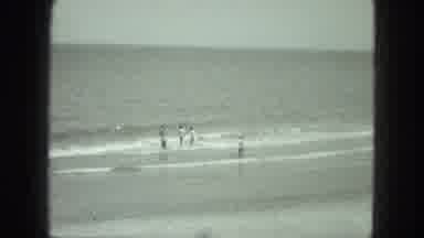 VENICE ITALY-1975: 4 People Playing And Having Fun In The Waves At The Beach