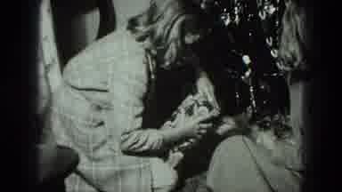 Milwaukee Wisconsin USA-1975: Young Woman Carefully Unwraps Christmas Presents