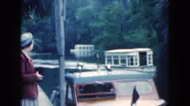 Florida USA (1975): Woman Wearing Brown Coat Waits For White Ferry Boat Churning