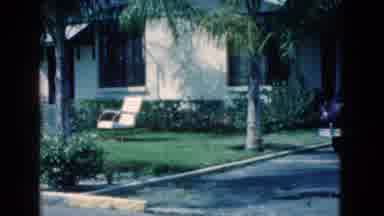 Florida USA (1975): Woman Enjoys Sitting On Her Front Lawn Reading A Newspaper