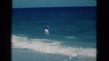 FLORIDA USA-1975: Man Walks Into Ocean and Is Hit by Small Waves