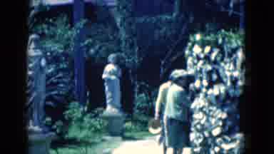 Florida USA (1975): Two Elderly Woman Look At White Bush In Front Of Statues