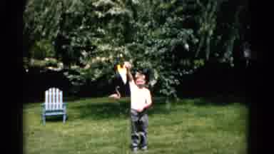 Florida USA (1975): Young White Boy Shows Off Yellow And Blue Pendant In Yard