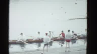 Boston Mass USA (1975): A Rowboat Team Pushes Off The Dock To Race Another